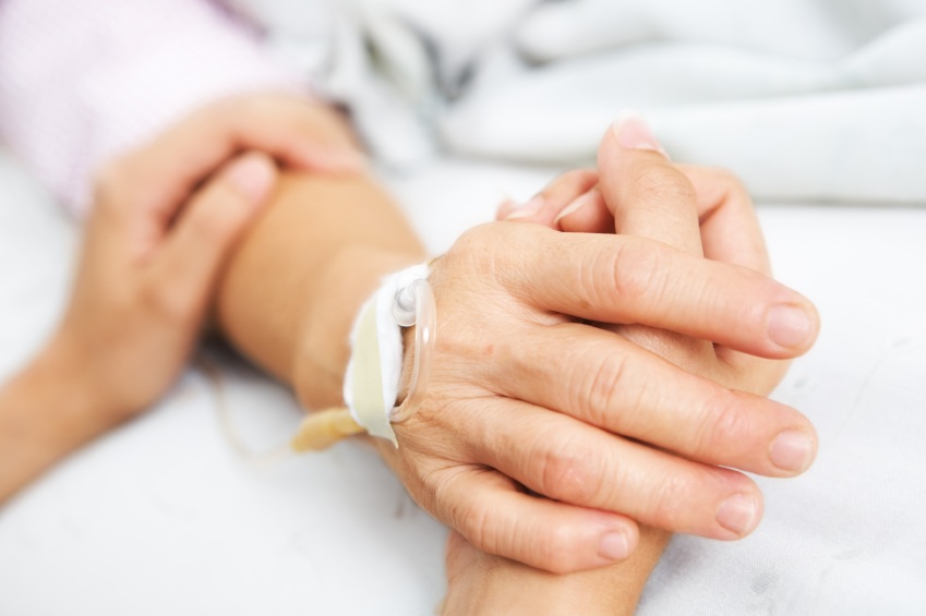 Daughter holding her mother hand in hospital